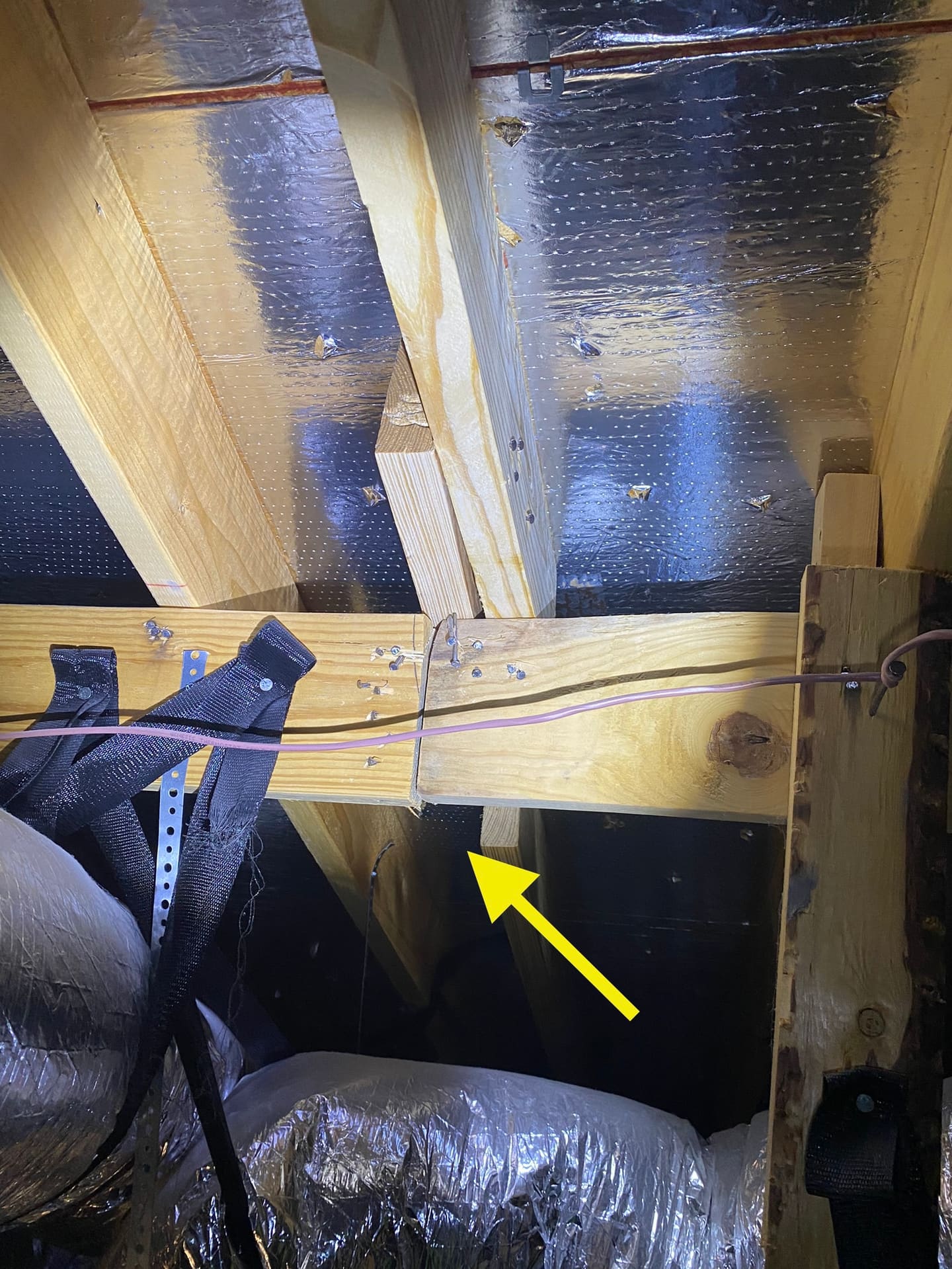 Attic insulation and wiring inspected during a buyer's home inspection, with an area of concern marked for the report.