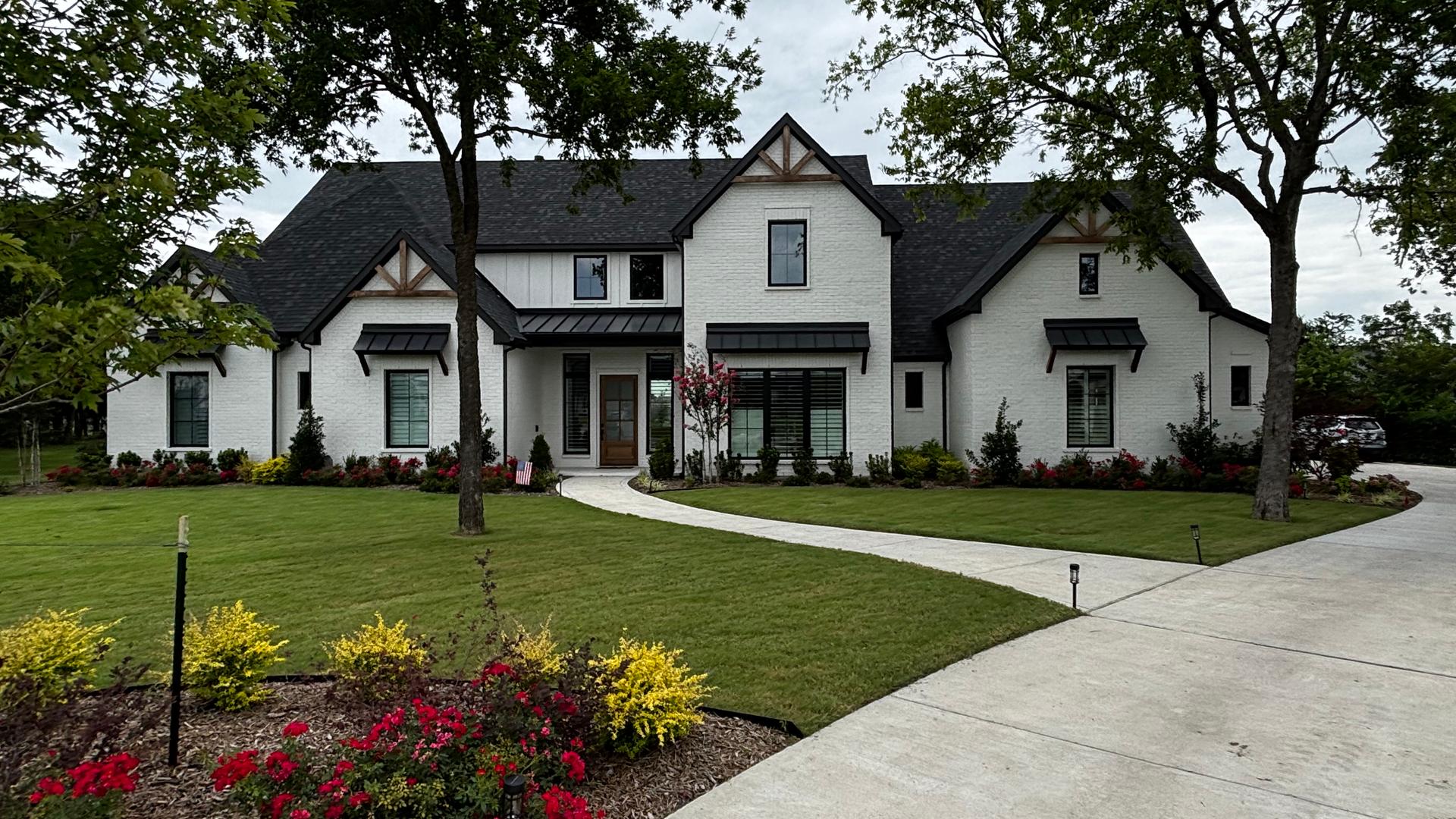 Exterior of a newly built single-story brick home with a dark shingle roof in Aubrey, TX.