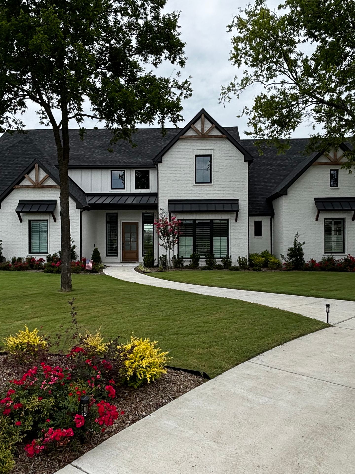 A modern farmhouse-style home in Aubrey, TX, about a year after closing, with an established lawn and landscaping.